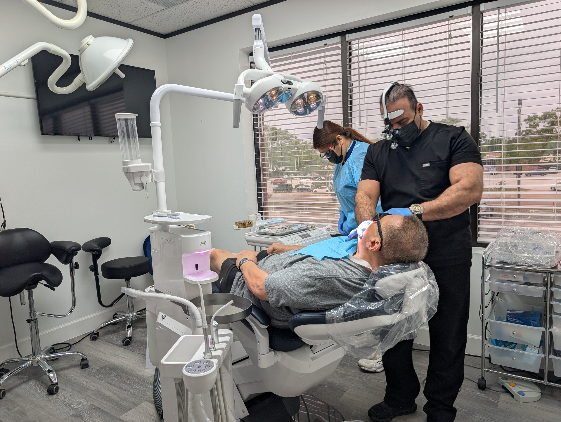 Dr. Firas and assistant performing an implant procedure in the operatory
